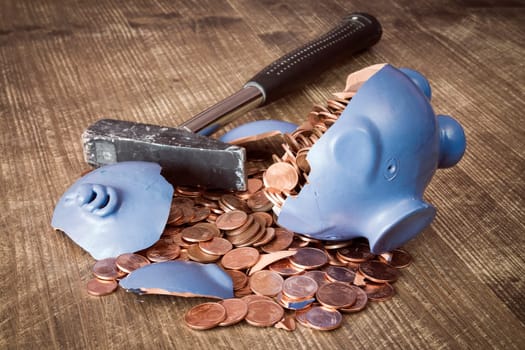 Broken piggy bank with hammer and money