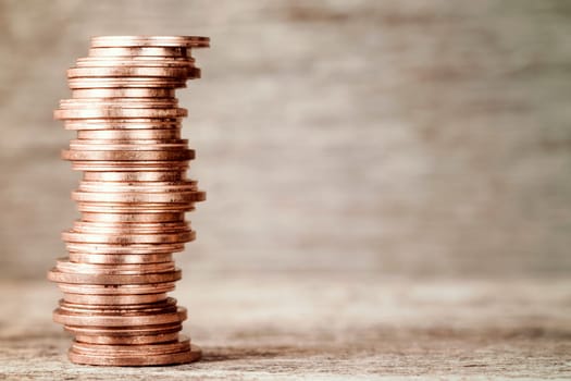 Close-up of stacked copper coins on the wooden background