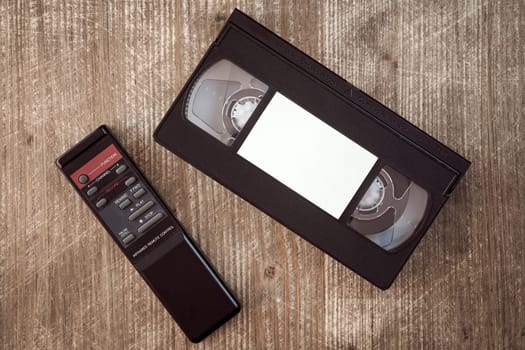 VHS video tape cassette and remote control on wooden background.Copy-space.