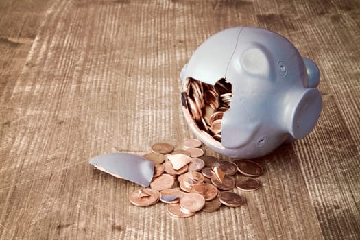 Broken piggy bank with and money on wooden background