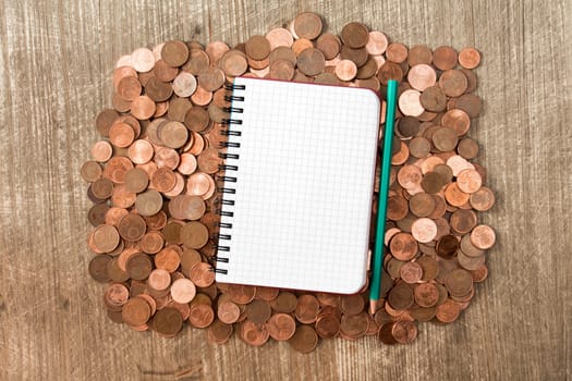Blank notebook on the heap of euro cent coins of different denominations