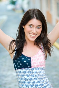 Portrait of a teenage girl smiling with her arms raised