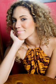 Portrait of a teenage girl smiling with her hand on her chin