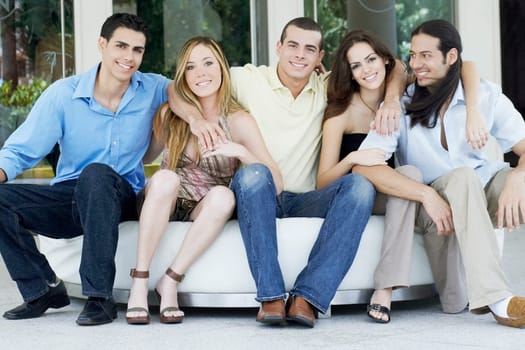 Group of friends sitting together on a couch and smiling