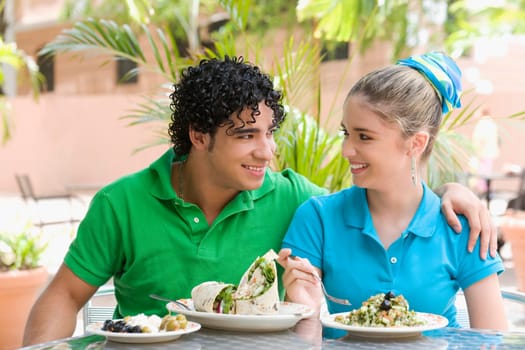 Close-up of a young man and a teenage girl sitting at a table in a restaurant