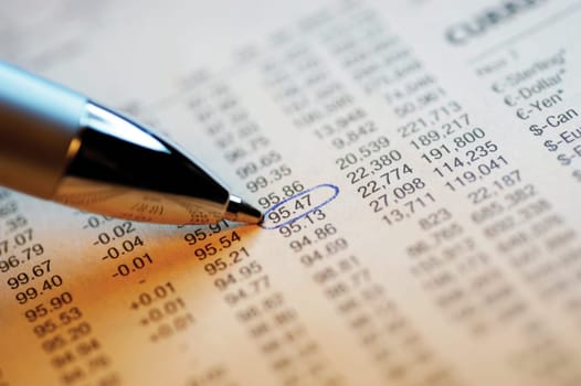 List of financial figures and pen, close-up