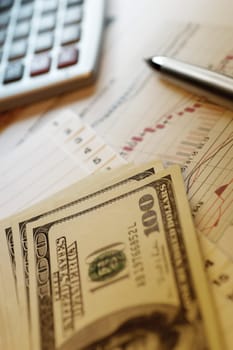 Pen, calculator and financial graphs, close-up