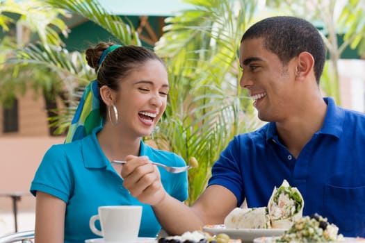 Close-up of a young man and a teenage girl sitting in a restaurant and smiling