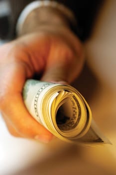 Businessman holding bankroll of United States currency, close-up