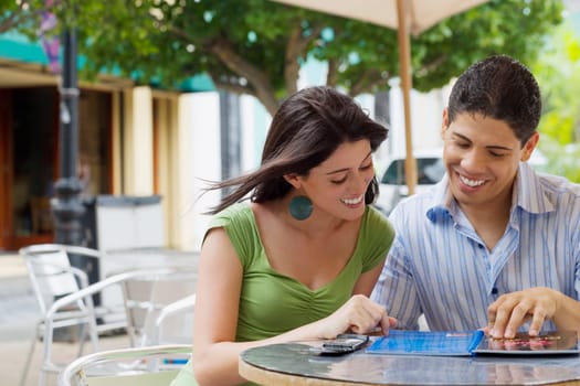 Close-up of a teenage girl and a young man reading a menu at a restaurant
