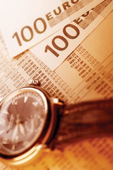 Watch, Euro bank notes and paper with financial figures
