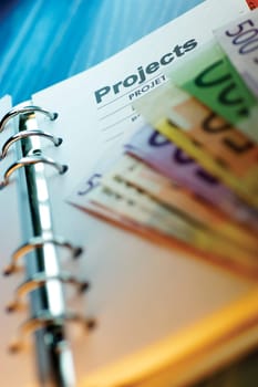 Close-up of assorted Euro banknotes on a diary