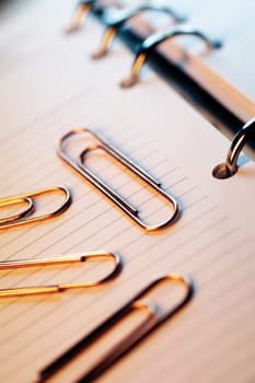 Paper clips on top of appointment book, close-up