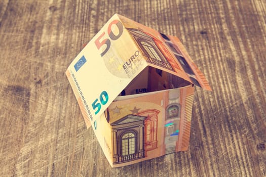 House made of Euro banknotes on a wooden background