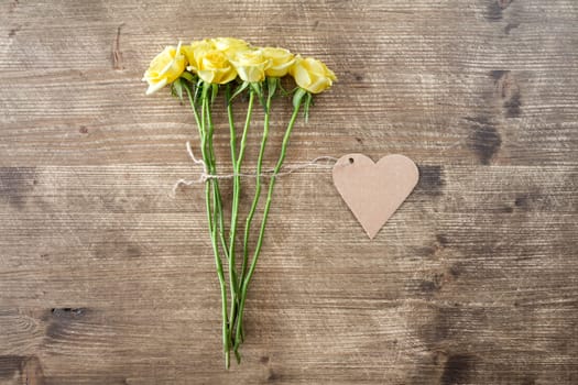 Bunch of yellow roses with heart shaped tag