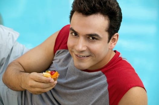 Portrait of a young man holding a cupcake