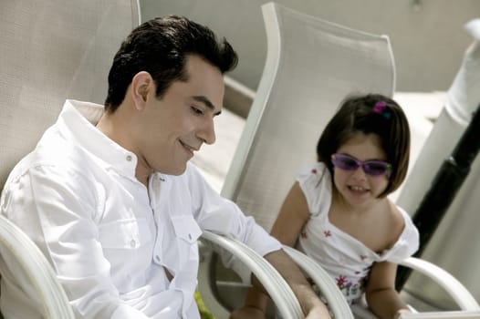 Father with his daughter sitting on armchairs