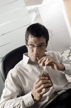 Close-up of a businessman sipping a drink with a straw