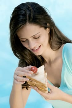 Close-up of a young woman holding a sandwich