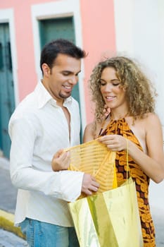 Mid adult man and a teenage girl holding a shopping bag and examining a top