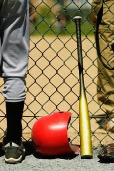 Low section view of two boys standing on either sides of a chain-link fence