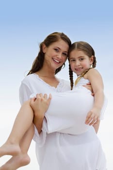 Portrait of a young woman carrying her daughter