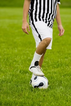 Low section view of a soccer player resting his foot on a soccer ball