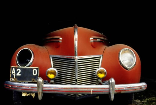 Close-up of a vintage car with a broken headlight