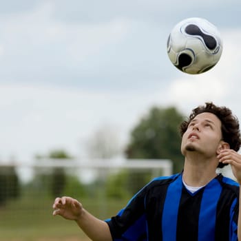 Close-up of a soccer player heading a soccer ball