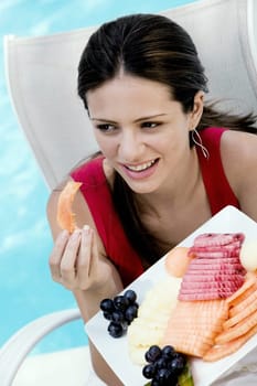 Close-up of a young woman eating fruit salad