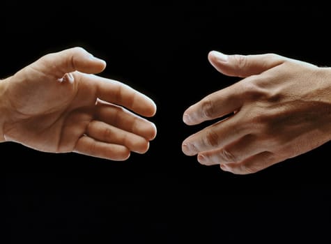 Close-up of two hands reaching towards each other