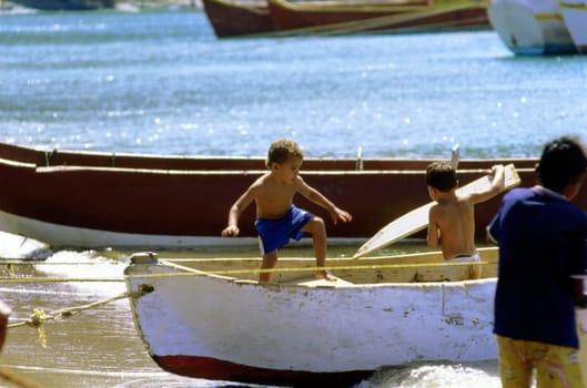 Three boys playing in a boat