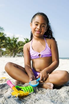 Portrait of a girl playing with sand on the beach