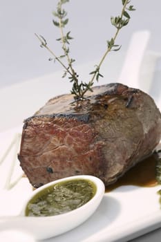 Close-up of a meat loaf with a spoon full of gravy in a plate