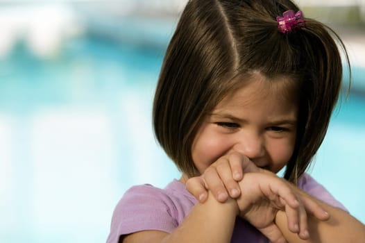 Close-up of a girl covering her mouth with her hands