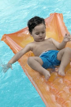 High angle view of a boy floating on a pool raft