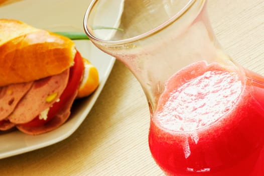 Close-up of a sandwich on a plate with a glass of juice