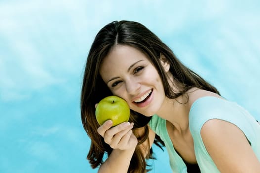 Portrait of a young woman holding an apple