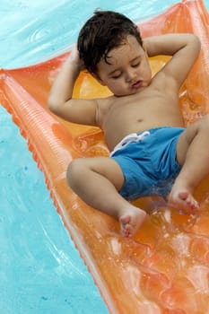High angle view of a boy floating on a pool raft