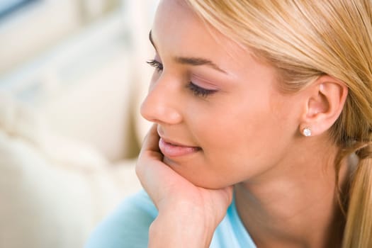 Close-up of a young woman sitting with her hand on her chin