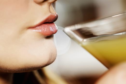 Close-up of a young woman drinking a glass of cocktail