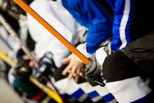 Mid section view of a group of ice hockey players holding ice hockey sticks