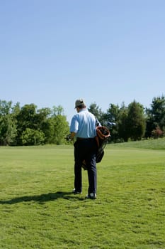 Rear view of a man carrying a golf bag