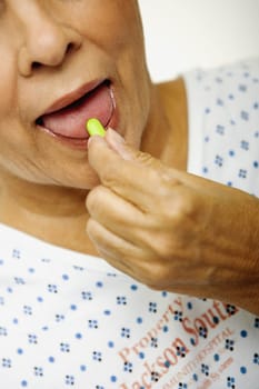 Close-up of a senior woman taking a pill