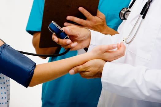 Mid section view of a male doctor measuring blood pressure of a female patient
