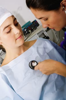 Close-up of a female doctor examining a female patient with a stethoscope