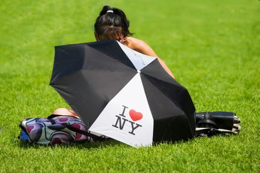 Close-up of an umbrella with a girl sitting behind it