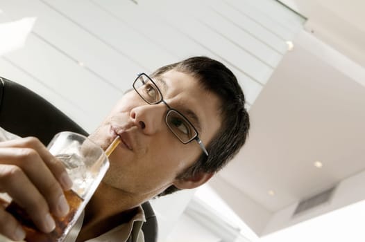 Close-up of a businessman sipping a drink with a straw