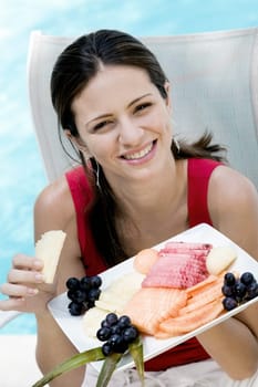Portrait of a young woman holding food in a tray