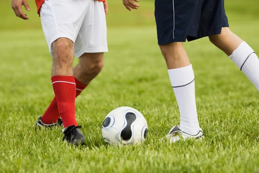 Low section view of two soccer players playing soccer